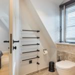 Badezimmer mit Toilette und Fenster. Tür führt in Schlafzimmer.