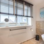 Badezimmer mit Fenster, Toilette und Wandbild
