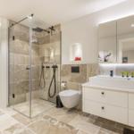 Bad mit Dusche, Waschbecken und Toilette. Sauna ist im Hintergrund sichtbar.