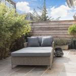 Terrasse mit Liege, Pflanzen und Holzgeländer