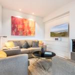Wohnzimmer mit Sofa, Kamin und Fernseher an der Wand.