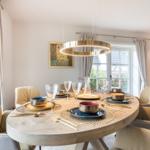Runder Esstisch mit Stühlen und Tischdekoration im Esszimmer.