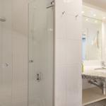 Bathroom with shower, sink, and mirror.