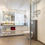 Bathroom with sink, mirror, toilet, and shower.