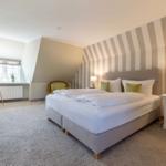 Bedroom with bed, nightstand, and TV mounted on the wall.