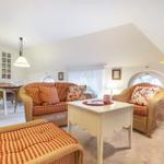 Living and dining area with seating, table, and windows.