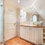 Bathroom with shower, sink, and mirrors.