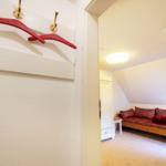 Bedroom with sofa and coat hooks on the wall