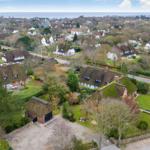 Village with thatched houses and view of the sea.