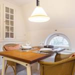 Dining table with chairs and glass cabinets on the wall.