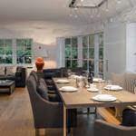 Esszimmer mit Tisch und Stühlen. Wohnbereich mit Sofa und Fenstern.