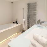 Badezimmer mit Badewanne, Waschbecken und Heizkörper