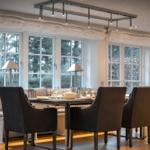 Esszimmer mit Tisch, Stühlen und großen Fenstern