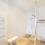 Badezimmer mit Dusche, Toilette und Heizkörper
