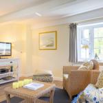 Wohnzimmer mit Wicker-Sofa, Fernseher und Fenster mit Blick.