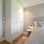 Schlafzimmer mit Bett, Nachttisch und Kleiderschrank.