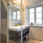 Bad mit Dusche, Waschbecken und Fenster