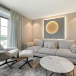 Ein Wohnzimmer mit Sofa, Sessel und runden Tisch.