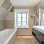Badezimmer mit Badewanne, Waschbecken und Fenster