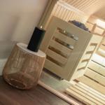 Sauna mit Holzbank und dekorativer Lampe im Vordergrund.