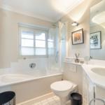 Bathroom with bathtub, shower, sink, and toilet.