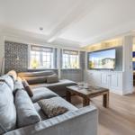 Wohnzimmer mit Sofa, Fernseher und Holzboden. Wand mit blau-weißem Muster.
