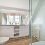 Badezimmer mit Dusche, Waschbecken und Fenster