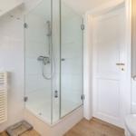 Badezimmer mit Dusche, Toilette und Heizung.