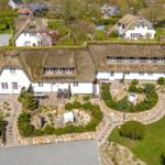 Traditionelles Haus mit Strohdach und gepflegtem Garten