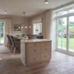 Dining room with kitchen island, seating area, and glass doors to the garden.