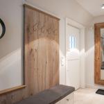 Entrance with wooden wall, hooks, and mirror. Staircase visible in the background.