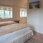 Bedroom with double bed, windows, and glass-walled shower.