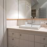 Bathroom with sink, mirror, and wooden top edge.