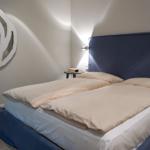 Bedroom with bed, headboard, and wall mirror