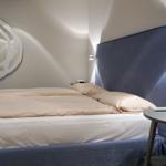 Bedroom with bed, headboard, and wall mirror.