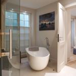 Bath with freestanding bathtub, sauna, and view into bedroom