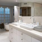 Double sink with mirrors, shower, and sauna in bathroom