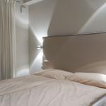 Bedroom with double bed, headboard, and window with curtains.