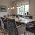 Dining room with wooden table, chairs, and window view