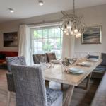 Dining area with long table, chairs, and window view