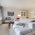 Wohnzimmer mit Sofa, Tisch und Fenster. Hintergrund: Wandbild und Schrank.