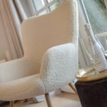 A cream-colored seating area beside a window with a tray holding champagne and glasses.