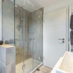 Bathroom with shower, sink, and towels.