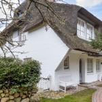 White walls with thatched roof, white bench, and paved terrace.