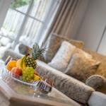 Living room with sofa, fruit bowl, and window view.