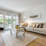 Living room with sofa, seating group, and glass doors to terrace.