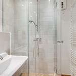 Badezimmer mit Dusche, Waschbecken und Heizkörper