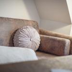 Ein Sofa mit Kissen in einem Raum mit schrägen Wänden.