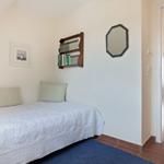 Bedroom with bed, wall shelf, and mirror