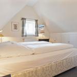 Bedroom with double bed, window, and wardrobe